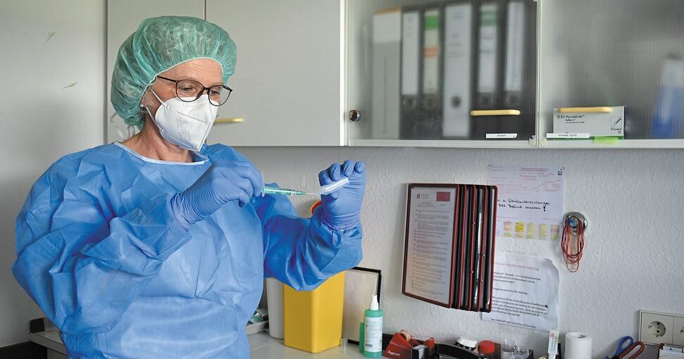 Susanne Zauner-Müller demonstriert, wie sie Kochsalzlösung aufzieht, um den Impfstoff von Biontech/Pfizer zu verdünnen. Wenn die Ärztin die Dosen tatsächlich vorbereitet, bleibt die Tür des Labors in der Hausarztpraxis geschlossen. Foto: Stephanie Na