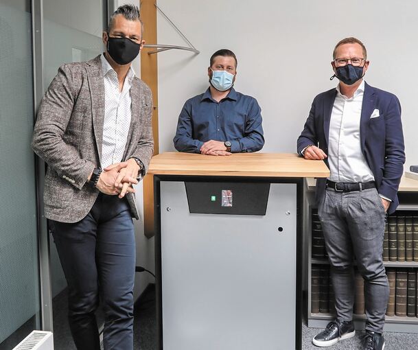 Hier dient der Luftfilter als Tisch: Alexander Weiss, Schubert-Geschäftsführer Florian Padotzke und Rüdiger Käss (von links) stehen am VSP-Luftreiniger. Foto: Ramona Theiss