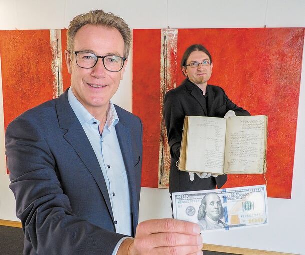 Steffen Döttinger (vorne) freut sich über den 100-Dollar-Schein, Kreisarchivar Wolfram Berner auch über die Geschichte. Foto: Holm Wolschendorf