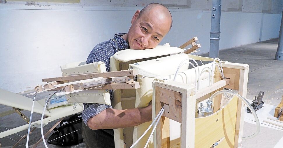 Einmal drücken, bitte: Brad Hwang testet Teile seines Umarmungsgeräts (links), das an den Webstuhl (oben) montiert wird. Für das Projekt konnte sich der gebürtige Südkoreaner alte Gerätschaften aus einer Kornwestheimer Scheune holen. Fotos: Holm Wols