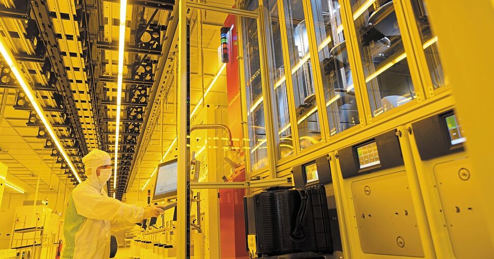 Ein Mitarbeiter steht während eines Presserundgangs in der neuen Halbleiterfabrik von Bosch im Reinraum an einer Maschine für die Bestückung von 300-Millimeter-Wafern. Foto: Robert Michael/dpa
