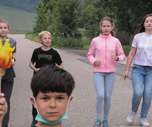 Raphael aus Klasse 1 trägt die „Fackel“. Noah und Janic aus Klasse 5 sowie Josie und Marie aus Klasse 7 laufen in den Weinbergen.Foto: Alfred Drossel