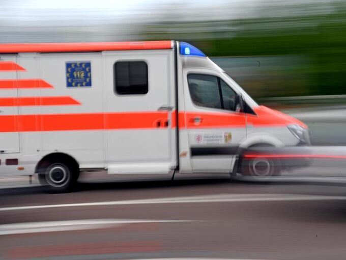 Ein Krankenwagen fährt mit Blaulicht auf einer Straße