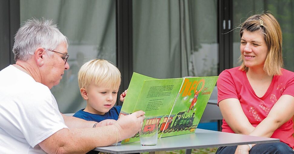 Auch die Vorlesepaten sind ein fester Bestandteil des Angebots. Hier liest Gisela Scheck (links) dem vierjährigen Philipp vor. Foto: Holm Wolschendorf