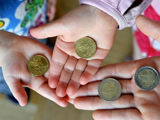 Kinder halten Euro-Münzen in den Händen