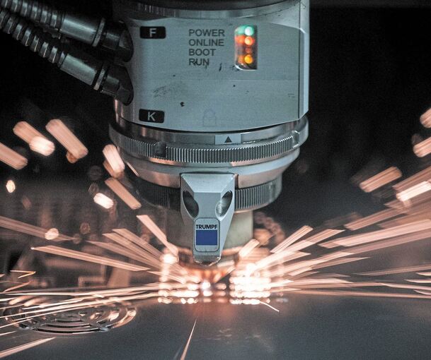 Ein Laser schneidet im Ditzinger Besucherzentrum des Maschinenbauers Trumpf ein Blech. Foto: Marijan Murat/dpa