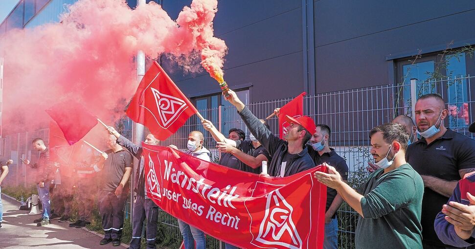 Roter Rauch vor dem Sachsenheimer Dräxlmaier-Werk: Mitarbeiter am Freitagmittag bei einem Warnstreik. Foto: Holm Wolschendorf