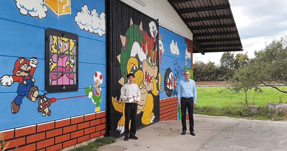 Michael Kaufmann (links) erhält für das Graffitiprojekt an der Obsterfassungshalle einen Gutschein von Bürgermeister Torsten Bartzsch.Foto: privat