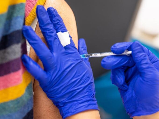 Die Mitarbeiterin eines Impfzentrums impft eine Frau gegen Corona