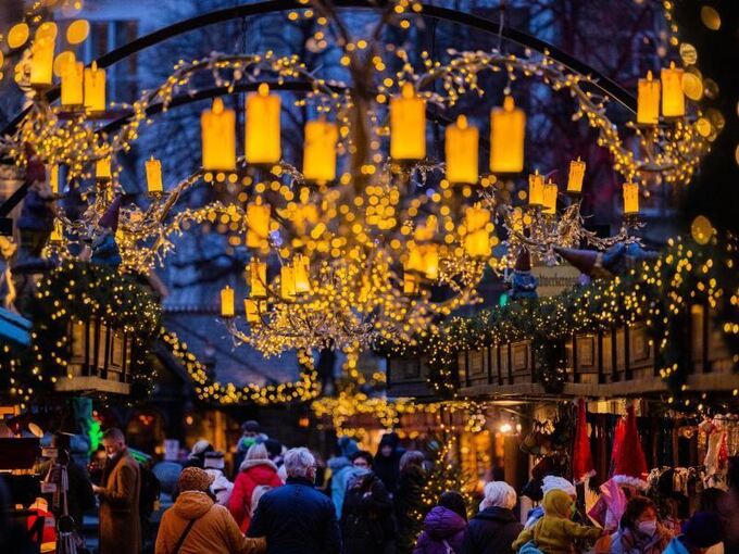 Besucher gehen über einen Weihnachtsmarkt