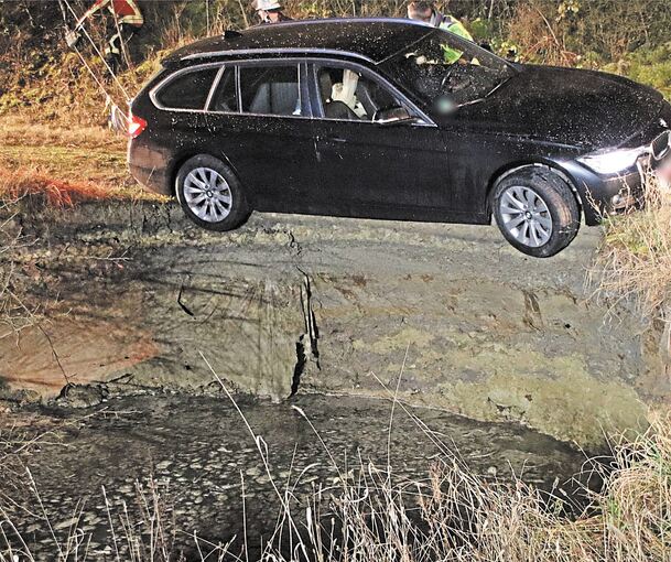 Das Fahrzeug des Ehepaars steht am Rande des Lochs, wo das Erdreich aberutscht ist. Foto: 7aktuell.de | Hessenauer