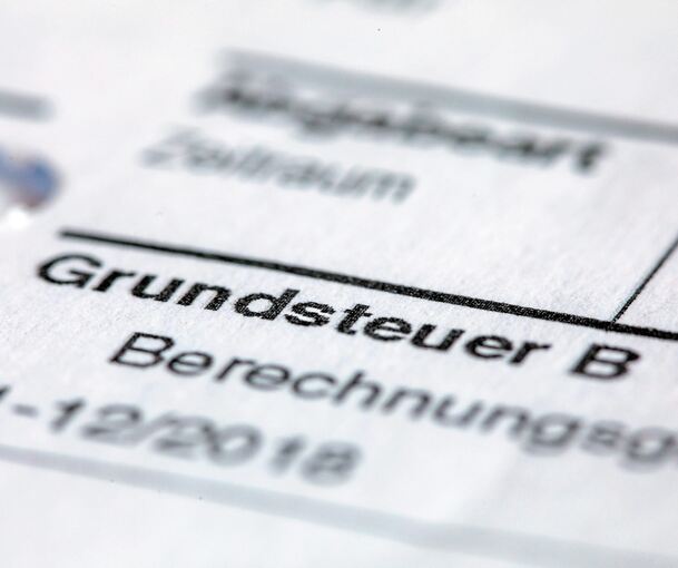 Ein Abgabenbescheid für die Entrichtung der Grundsteuer liegt hier auf einem Schreibtisch. Foto: Jens Büttner/zb/dpa