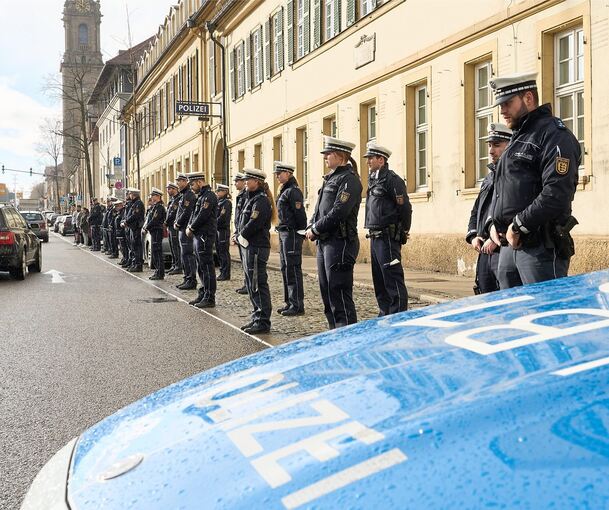 Die Einsatzkräfte stehen aufgereiht vor dem Revier an der B 27 und gedenken der Opfer aus Kusel. Foto: Andreas Becker