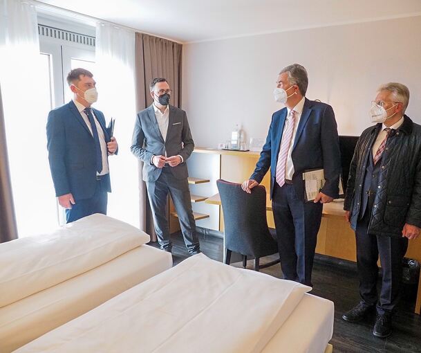 Aaron Müller zeigt den Politikern Siegfried Lorek, Dietmar Allgaier und Michael Makurath (von links) eines der Hotelzimmer, die für die Flüchtlinge vorbereitet worden sind. Fotos: Holm Wolschendorf