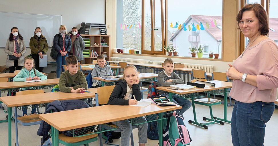 Elina Frenk (rechts) unterrichtet die ukrainischen Schüler auf Russisch. Im Hintergrund die Mütter, die ihre Kinder in die Schlößlesfeldschule gebracht haben. Foto: Andreas Becker