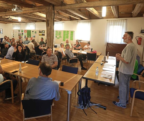 Argumente werden ausgetauscht: Gerhard Jüttner von den Naturfreunden Württemberg erläutert den Teilnehmenden seine Argumente gegen einen Gewerbepark bei Mundelsheim. Die Kritiker stellen ihren Protest bei der Infoveranstaltung auch bildlich dar. Foto
