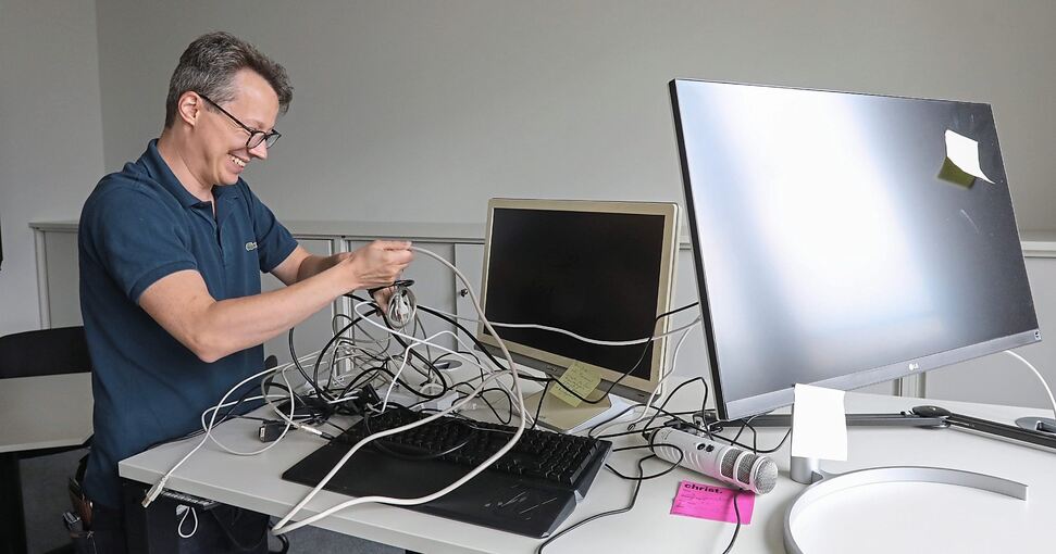 OPS-Schulleiter René Coels kämpft mit dem Kabel-Wirrwarr. Die IT-Spezialisten haben unterdessen im besonders gesicherten Netzwerkraum alles im Griff. Fotos: Ramona Theiss