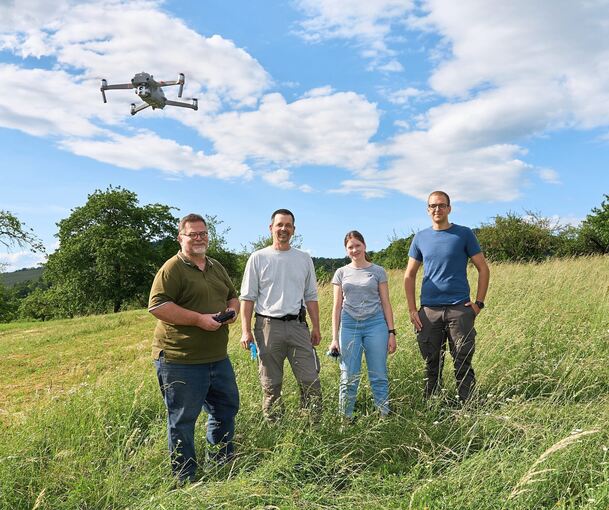 Erik Müller fliegt die Drohne. Michael Adam, Lara Bock und Nils Hamm (von links) laufen die Wiese ab. Foto: Andreas Becker