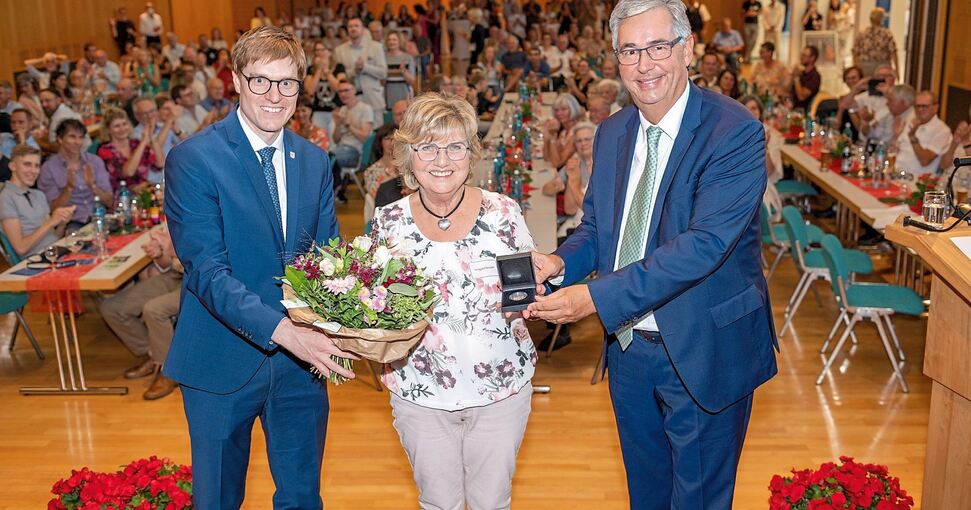 Irmgard Nesper erhält aus den Händen von Landrat Dietmar Allgaier die Staufer-Medaille; links Bürgermeister Markus Kleemann.