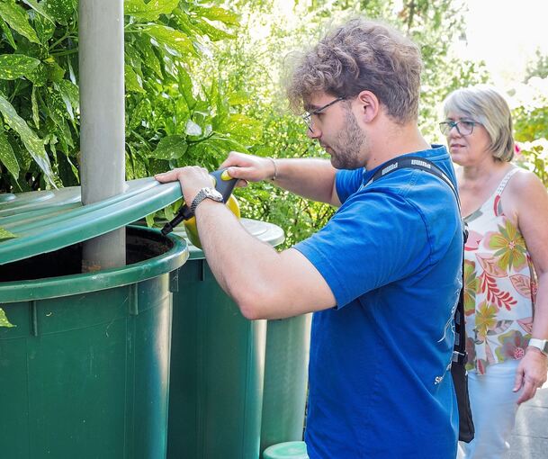 Lucas Auguanno spritzt in einen Wasserbehälter im Garten von Jutta Lindenmann ein Mittel gegen die Ausbreitung der Asiatischen Tigermücke.