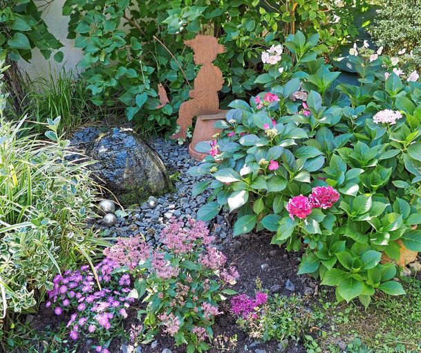 Stilvolle Deko-Objekte ergänzen die üppige Bepflanzung.