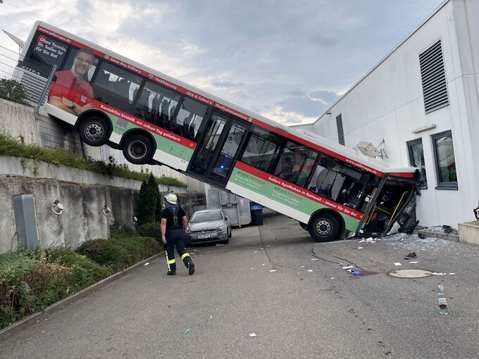 Bus stürzt über Abhang gegen Discounter