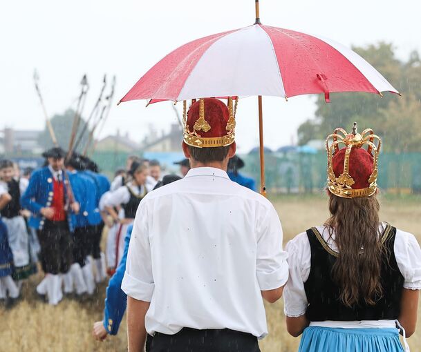 Das Königspaar sucht Schutz unterm Regenschirm.