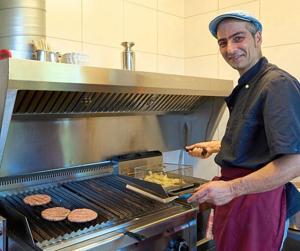 Auch Burger sind im Angebot – Inhaber Aristofanis Chatzidis steht oft und gerne in der Küche. Foto: Andreas Becker