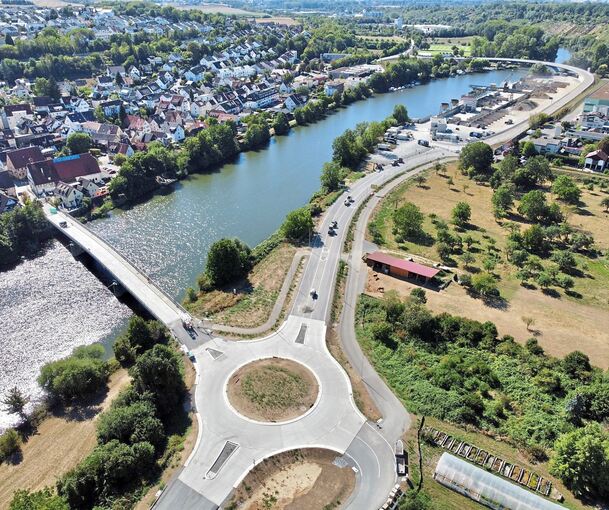 Die rund 1,2 Kilometer lange Benninger Ortsumfahrung soll Ende des Monats für den Verkehr freigegeben werden. Die alte Neckarbrücke (links) wird derzeit noch saniert. Rechts oben schwingt sich die neue Brücke über den Fluss. Foto: Holm Wolschendorf