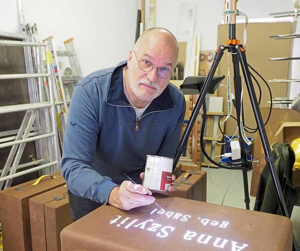 In der Werkstatt malt Jochen Faber vorsichtig die Buchstaben nach. Fotos: Holm Wolschendorf