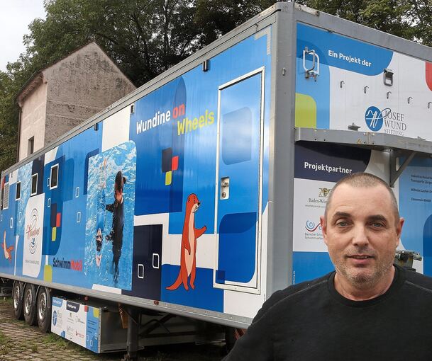 Jürgen Laub steht vor dem Lkw-Auflieger, in dem das SchwimMobil eingebaut ist.