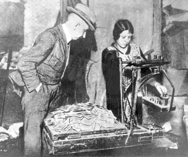 Das Foto von 1923 zeigt das Abwiegen von Geldscheinen in der Hyperinflation (Ort unbekannt). Archivfoto: dpa