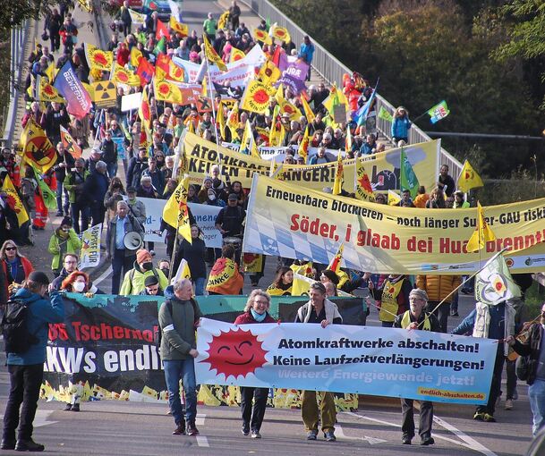 Knapp 400 Demonstranten ziehen mit Fahnen und Transparenten über die Neckarbrücke bei Kirchheim. Foto: Alfred Drossel