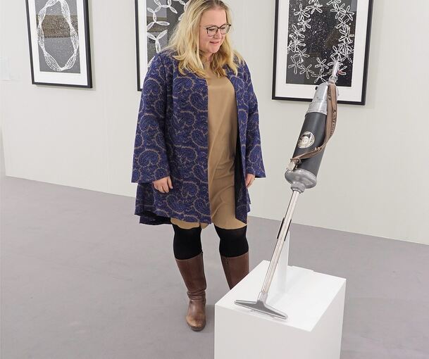 Ein Staubsauger – und dazu Kunst: Museumsleiterin Saskia Dams in der neuen Ausstellung. Foto: Holm Wolschendorf