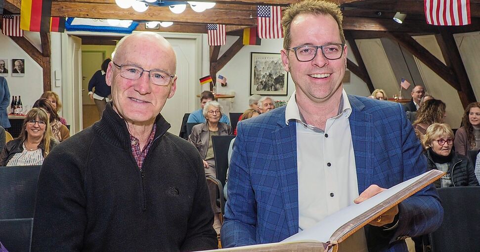 Washingtons Bürgermeister Doug Hagedorn (links) mit seinem Marbacher Amtskollegen Jan Trost und dem Goldenen Buch der Stadt. Foto: Holm Wolschendorf