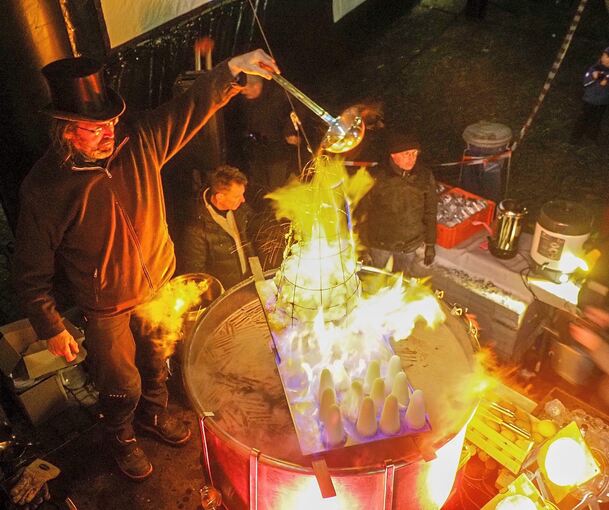Zeremonienmeister Hans Christoph Lenk in Aktion: Aus Rotwein, Rum und Zucker wird die beliebte Feuerzangenbowle. Foto: Holm Wolschendorf