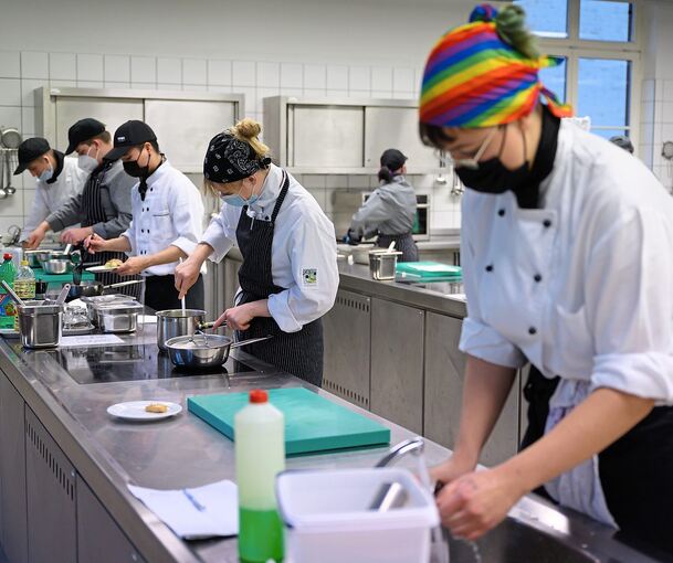 Auszubildende im zweiten Lehrjahr zum Koch arbeiten in einer Lehrküche. Foto: Robert Michael /dpa