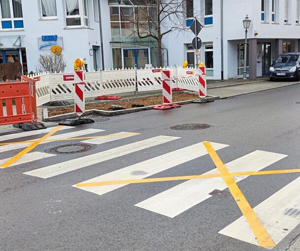Bitte diesen Zebrastreifen derzeit nicht benutzen, signalisieren die gelben Klebestreifen in der Mundelsheimer Straße. Der Grund: Es muss noch ein Mast für das beleuchtete Schild aufgestellt werden. Foto: Inge Hartmann