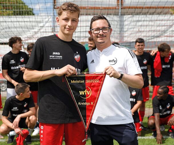 Juni 2022: Florian Noller (VfB Neckarrems 1913) erhält von Staffelleiter Frank Schneider (rechts) den WfV-Wimpel für die Meisterschaft in der B-Liga. Foto: Baumann