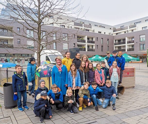 Kornwestheimer Schüler und Bürgermeisterin Martina Koch-Haßdenteufel trotzen dem durchwachsenen Wetter und freuen sich auf den Frühlingsmarkt. Foto: Holm Wolschendorf