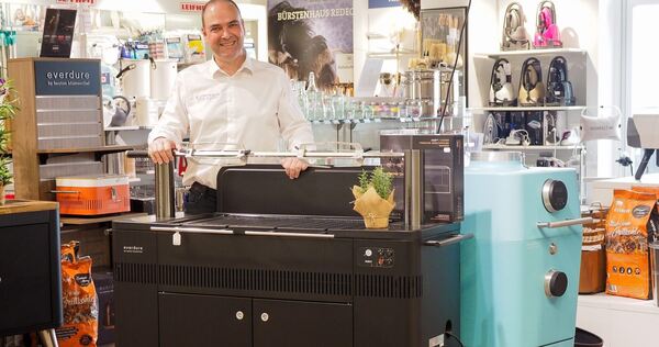 Gerald Pritz demonstriert den Holzkohle-Grill Hub: vom Spanferkel über Nackensteak kann hier alles gegrillt werden. Foto: Holm Wolschendorf