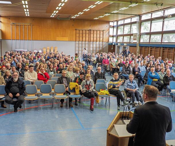 „Einen idealen Platz gibt es in Schwieberdingen nicht“: Bürgermeister Nico Lauxmann spricht vor rund 400 Zuhörern in der Turn- und Festhalle über die Flüchtlingssituation und die Suche nach Containerstandorten in seiner Gemeinde. Foto: Holm Wolschend
