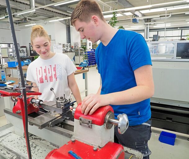 Clara (links) wird von Jonas angeleitet, wie sie an der Drehmaschine ihre Figuren herstellen kann. Fotos: Holm Wolschendorf