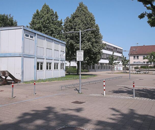 Zwischen Schule und Festhalle, dort wo jetzt noch die 25 Jahre alten Container stehen, sollen die zehn neuen Interimsklassenzimmer aufgestellt werden. Foto: Alfred Drossel