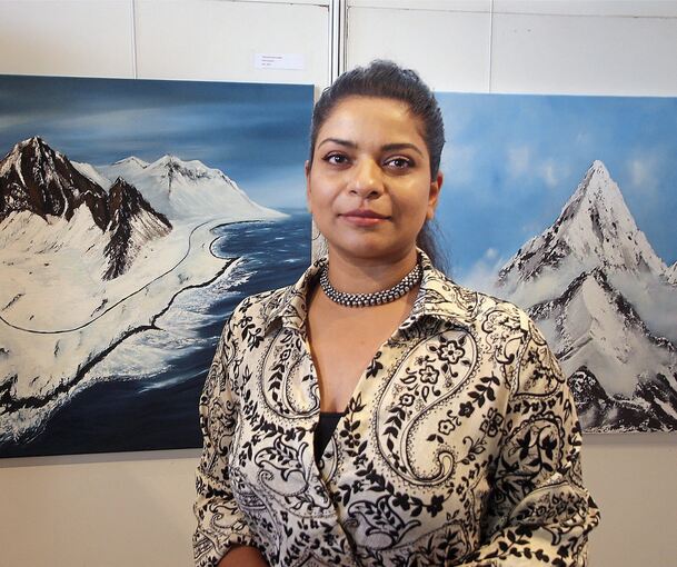 Künstlerin Gigitha Kalliyath vor Berglandschaften. Ihre Bilder sind im Besigheimer Rathaus zu sehen. Foto: Alfred Drossel