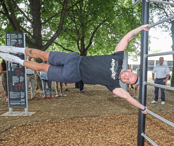 Nur mit Körpergewicht – und bei Janik Kreiser vielen Muskeln – kann man hier trainieren. Bürgermeister Nico Lauxmann hält sich lieber im Hintergrund. Foto: Ramona Theiss