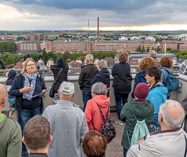 Stadtarchivarin Natascha Richter (links im Bild mit weiß-blauem Schal) gibt Erläuterungen zu den zahlreichen Landmarken, die vom Dach des Rathausturms aus zu sehen sind. Foto: Andreas Essig