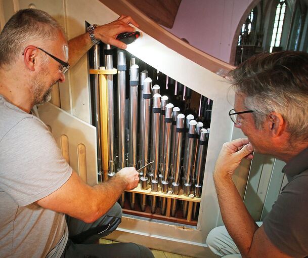Kirchenmusikdirektor Tobias Horn schaut Gilbert Scharfe bei der Arbeit zu.