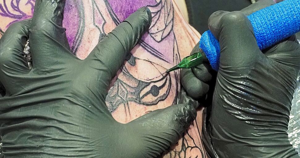 Der Trend nach Tattoos an allen erdenklichen Körperstellen scheint ungebrochen. Viele Besucher lassen sich gleich auf der Messe im Reithaus tätowieren. Foto: Holm Wolschendorf