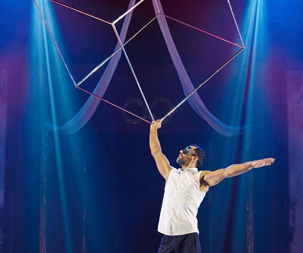 Oleg Valko jongliert mit einem großen silbrigen Metallwürfel. Foto: Alex Klein/p